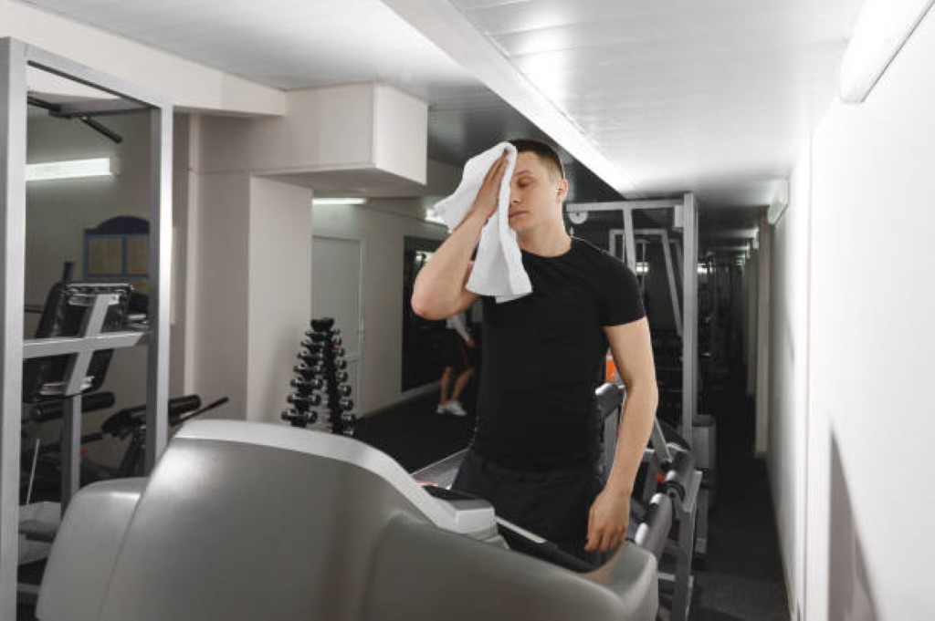 man removing sweating with wipes while doing gym